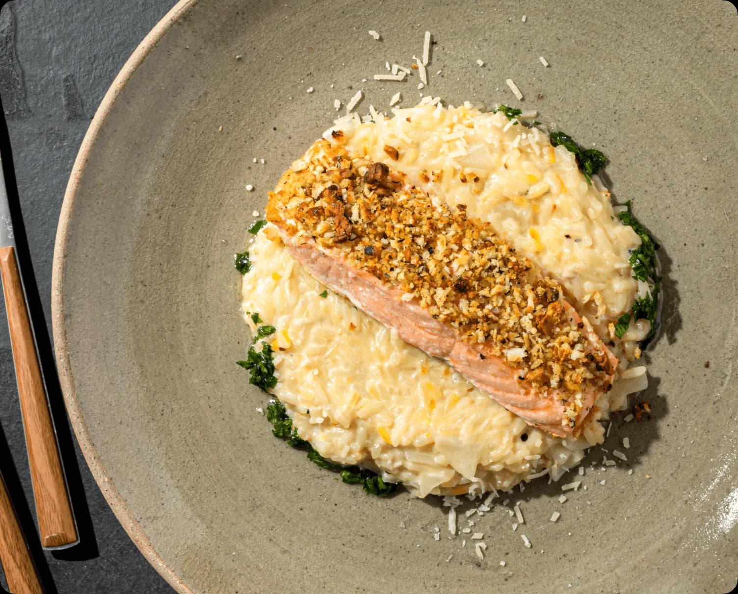 Bowl of food on a table with a smartphone in the background